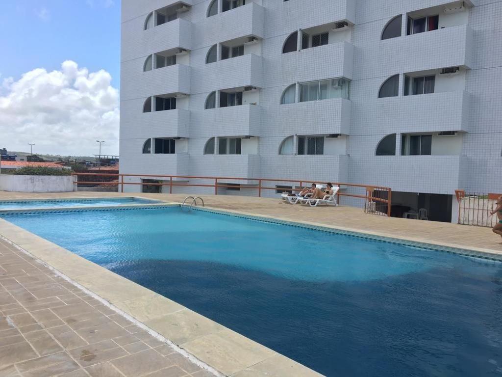 a swimming pool in front of a large building at Lindo Flat Verde Mar em São José da Coroa Grande, Pernambuco in São José da Coroa Grande