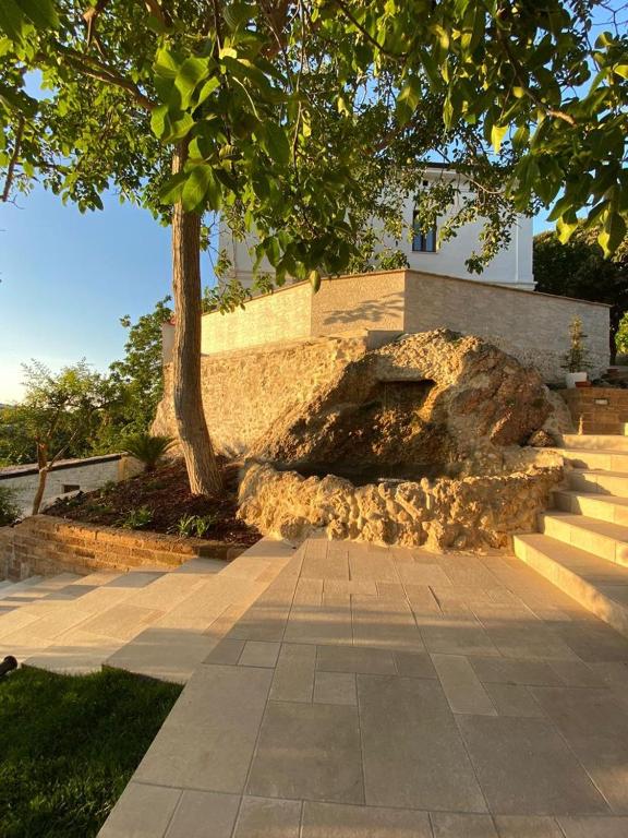 a building with stairs and a tree in front of it at Relais FraSimon Antico Casale in San Vito Chietino