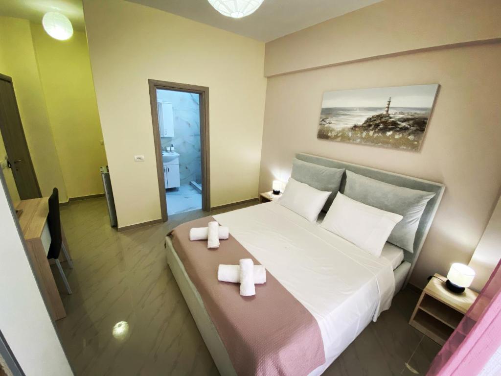 1 dormitorio con 1 cama grande con 2 velas en Elizabeth Apartments Himare, en Himare