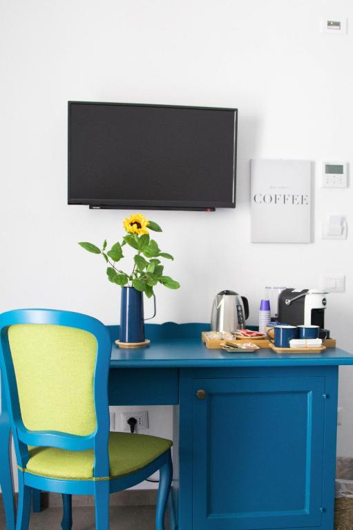 a blue desk with a blue chair and a vase with a flower at Isolotto Guest House in Porto Ercole