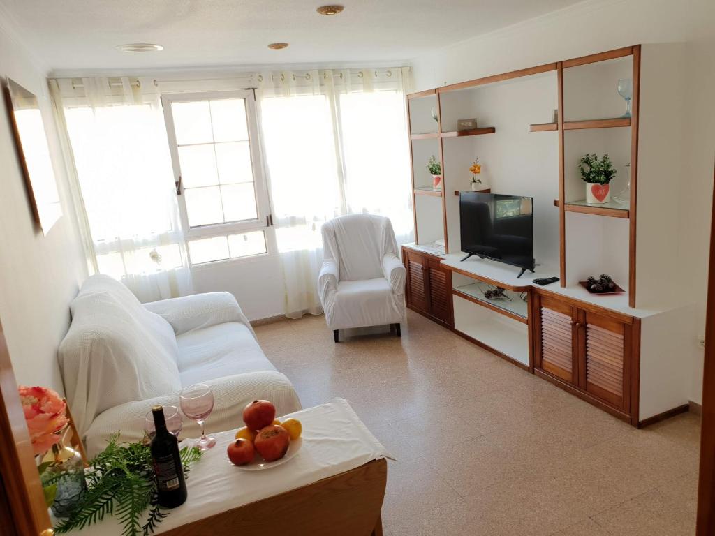 een woonkamer met een witte bank en een tv bij Holiday Home Salinas 7 in Alicante