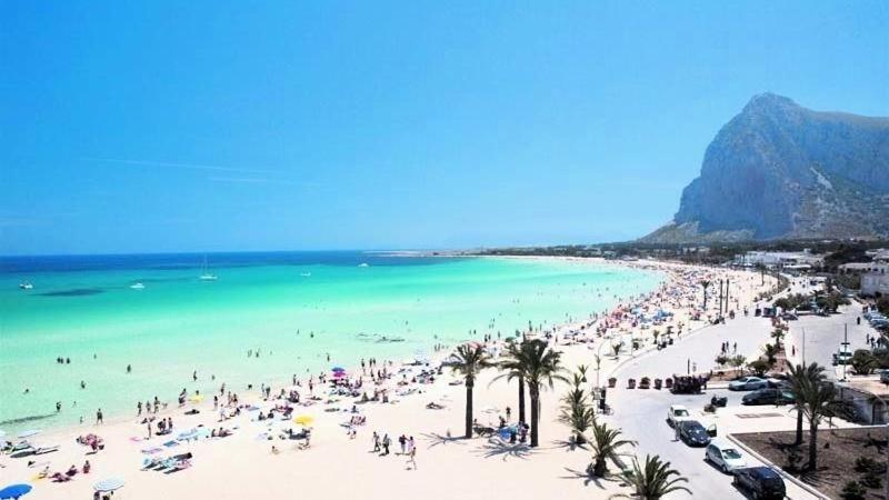 eine Gruppe von Menschen am Strand mit dem Meer in der Unterkunft Zà Lisa in San Vito lo Capo