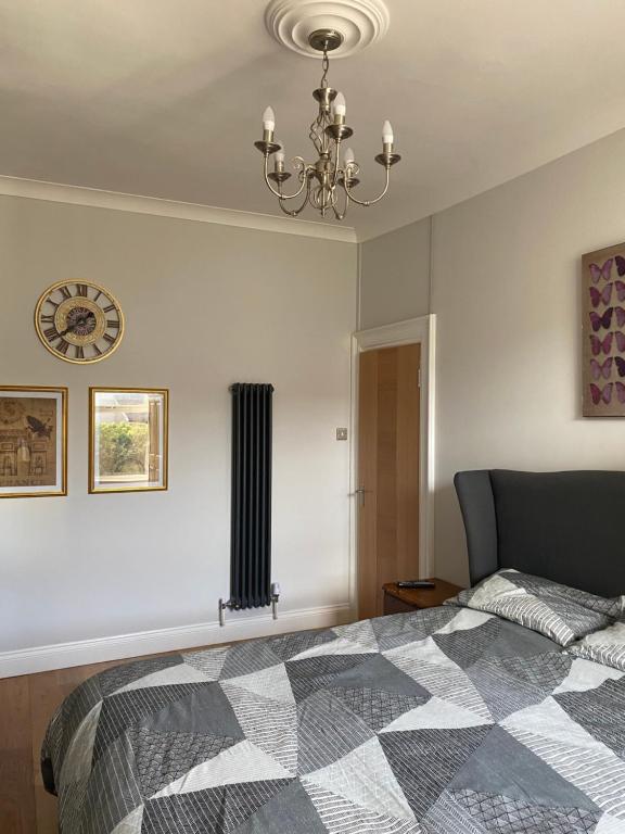 1 dormitorio con 1 cama y reloj en la pared en Beach Way en Berwick-Upon-Tweed