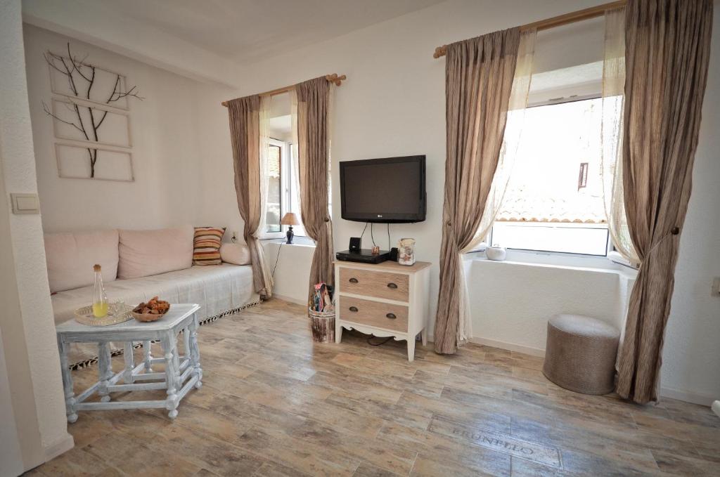 a living room with a couch and a tv at Bell Tower Apartment in Budva