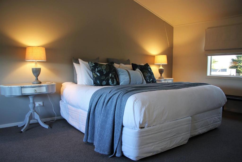 a bedroom with a large bed with two tables and two lamps at The Country Escape in Fernhill