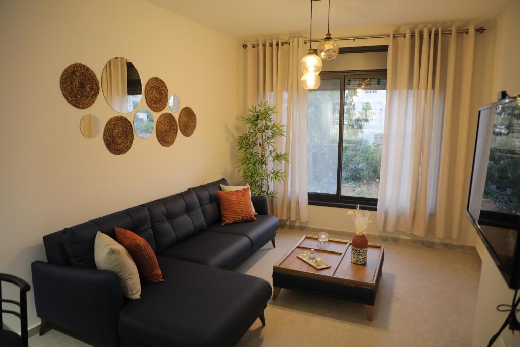 een woonkamer met een zwarte bank en een tafel bij RyLux Suits in Ramallah
