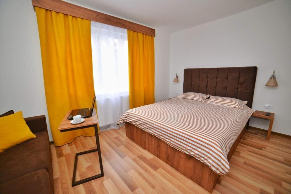 um quarto com uma cama, uma mesa e uma janela em Studio apartmani Emili Bijeljina apartman br 1 em Bijeljina
