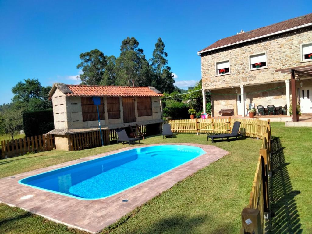 a swimming pool in the yard of a house at Casa Da Pallota in Moraña