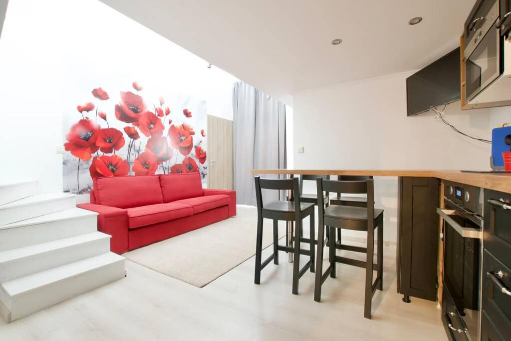 kuchnia i salon z czerwoną kanapą w obiekcie Standard Apartment by Hi5- Rose street's home (225) w Budapeszcie