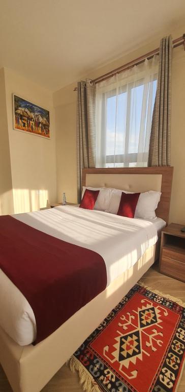 Un dormitorio con una cama grande con ventana. en Walabi Mara Hotel, en Narok