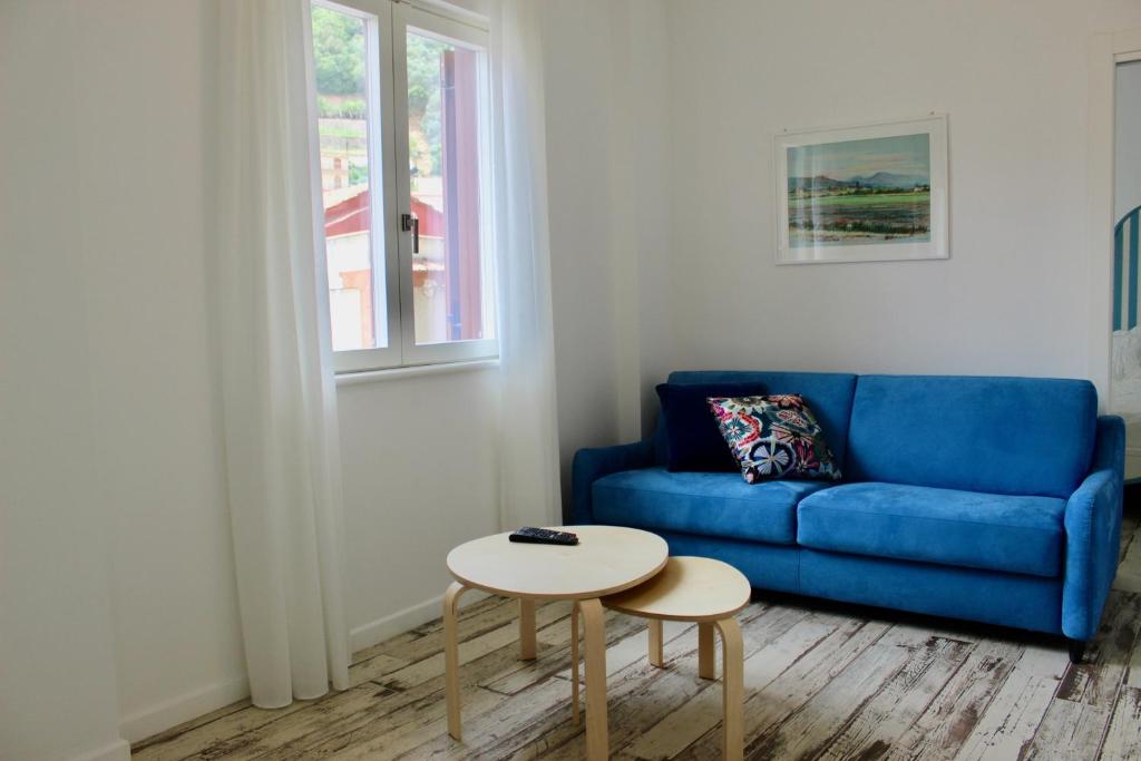 a living room with a blue couch and a table at Cetara Costa d'Amalfi Residence in Cetara