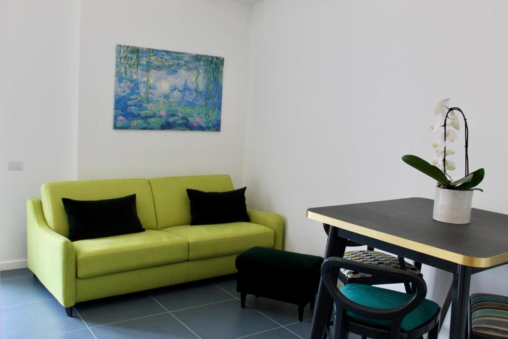 a living room with a green couch and a table at Cetara Costa d'Amalfi Residence in Cetara