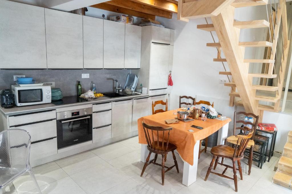 - une cuisine avec une table en bois et des chaises dans l'établissement Maison 3ch 65m2 en bord de mer, à Banyuls-sur-Mer