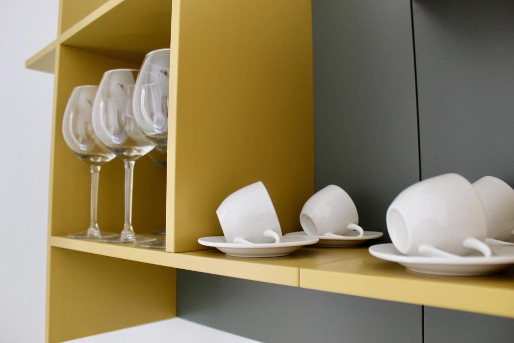 a shelf with plates and wine glasses on it at Cetara Costa d'Amalfi Residence in Cetara