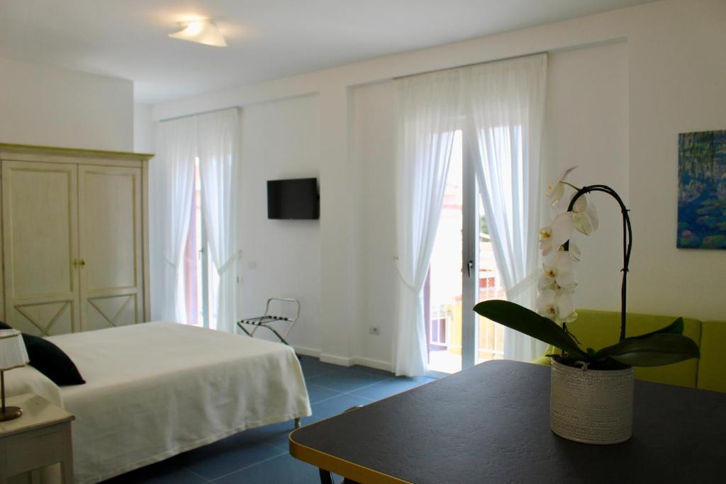 Un dormitorio con una cama y una mesa con una planta en Cetara Costa d'Amalfi Residence, en Cetara