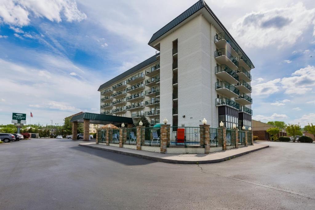 a hotel building with a fence in a parking lot at Park Grove Inn in Pigeon Forge