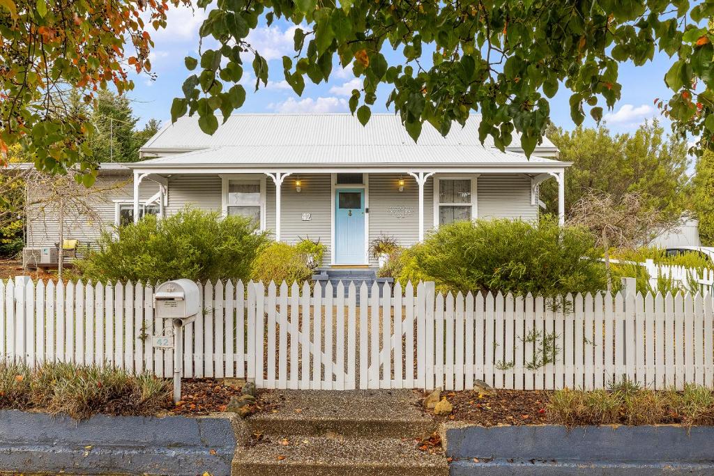 a white picket fence in front of a white house at Jack's House B&B Clare in Clare