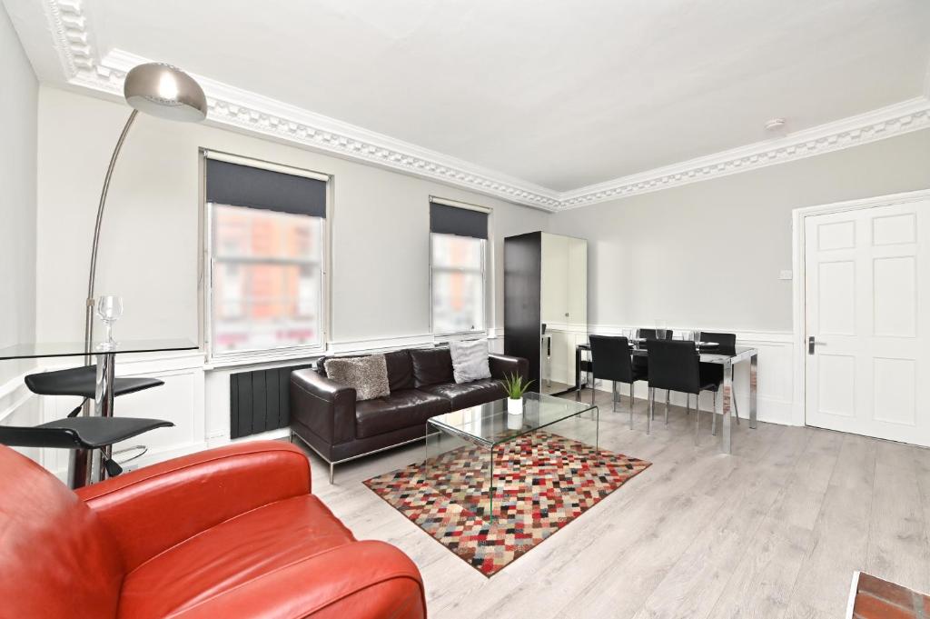 uma sala de estar com um sofá vermelho e uma mesa em Soho Apartment, Piccadilly & Regent Street em Londres
