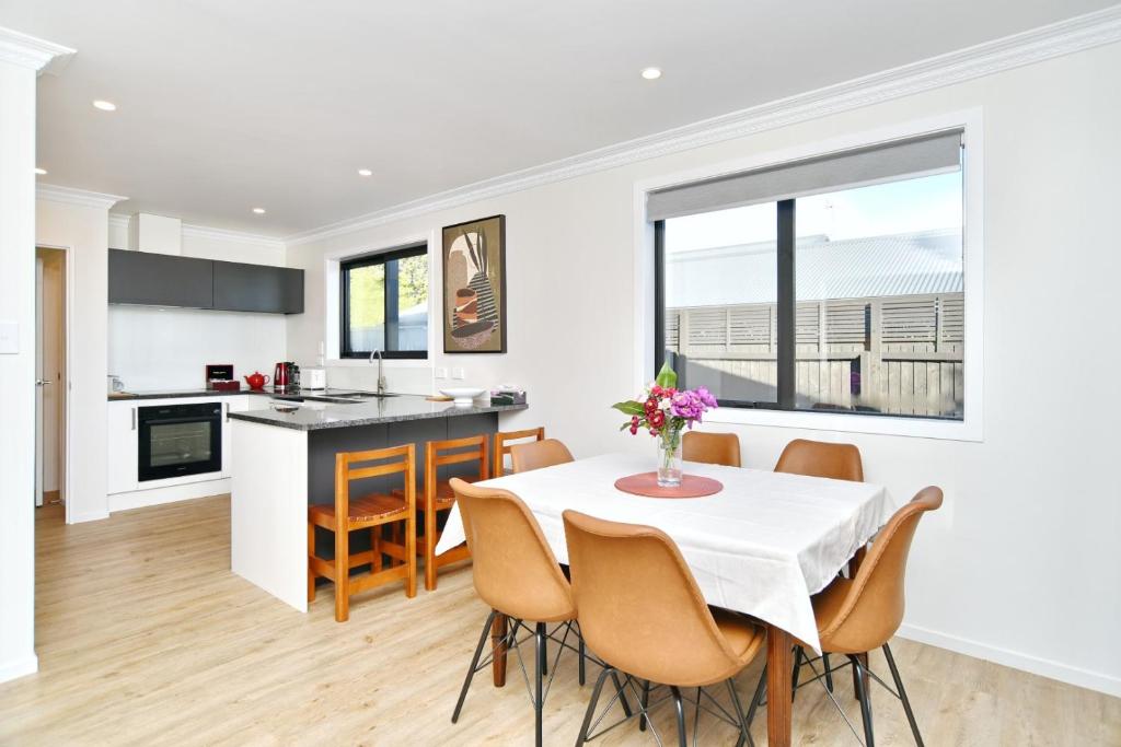 a kitchen and dining room with a table and chairs at Lavandula 4 - Christchurch Holiday Homes in Christchurch