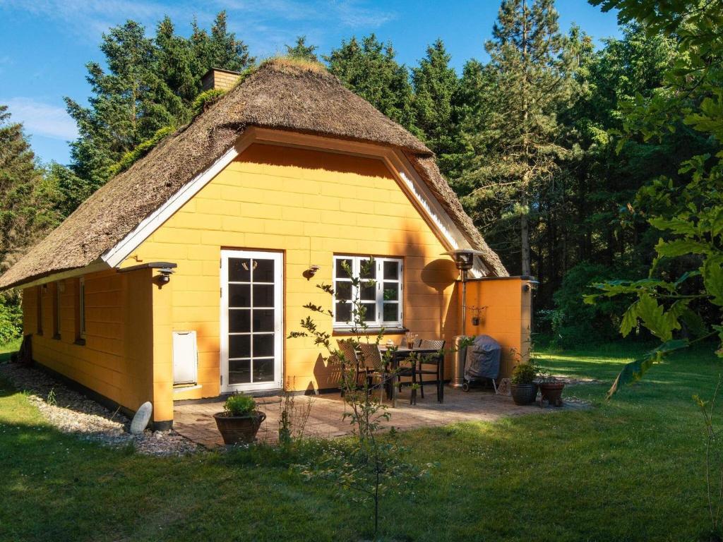 ein kleines gelbes Cottage mit einem Strohdach in der Unterkunft Holiday home Ulfborg XXIII in Ulfborg
