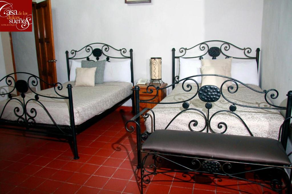 a bedroom with two beds and a chair in it at Casa de los Dulces Sueños in Morelia
