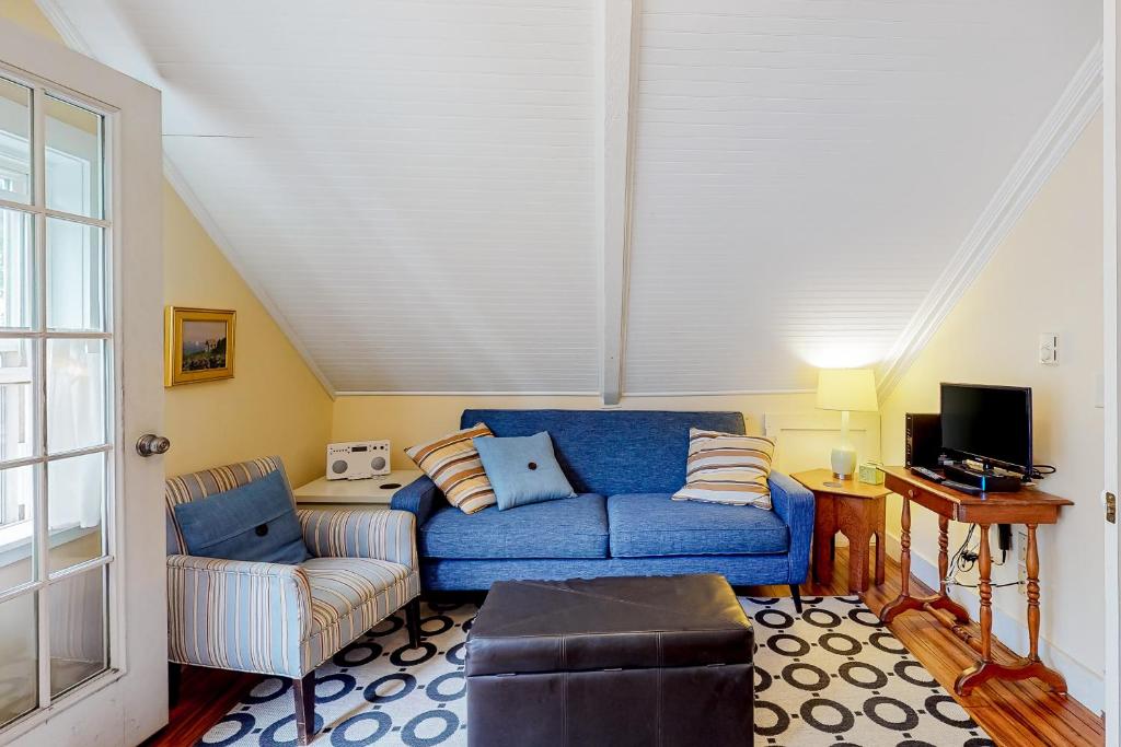 ein Wohnzimmer mit einem blauen Sofa und einem Stuhl in der Unterkunft Historic Jewel in Provincetown
