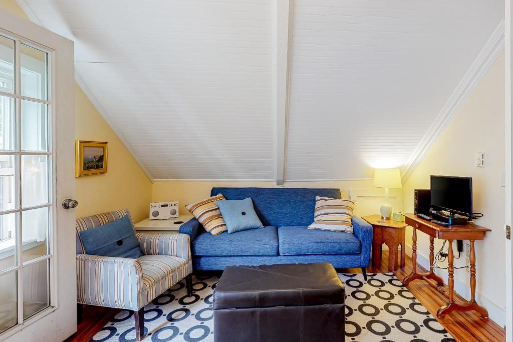 a living room with a blue couch and a chair at Historic Jewel in Provincetown