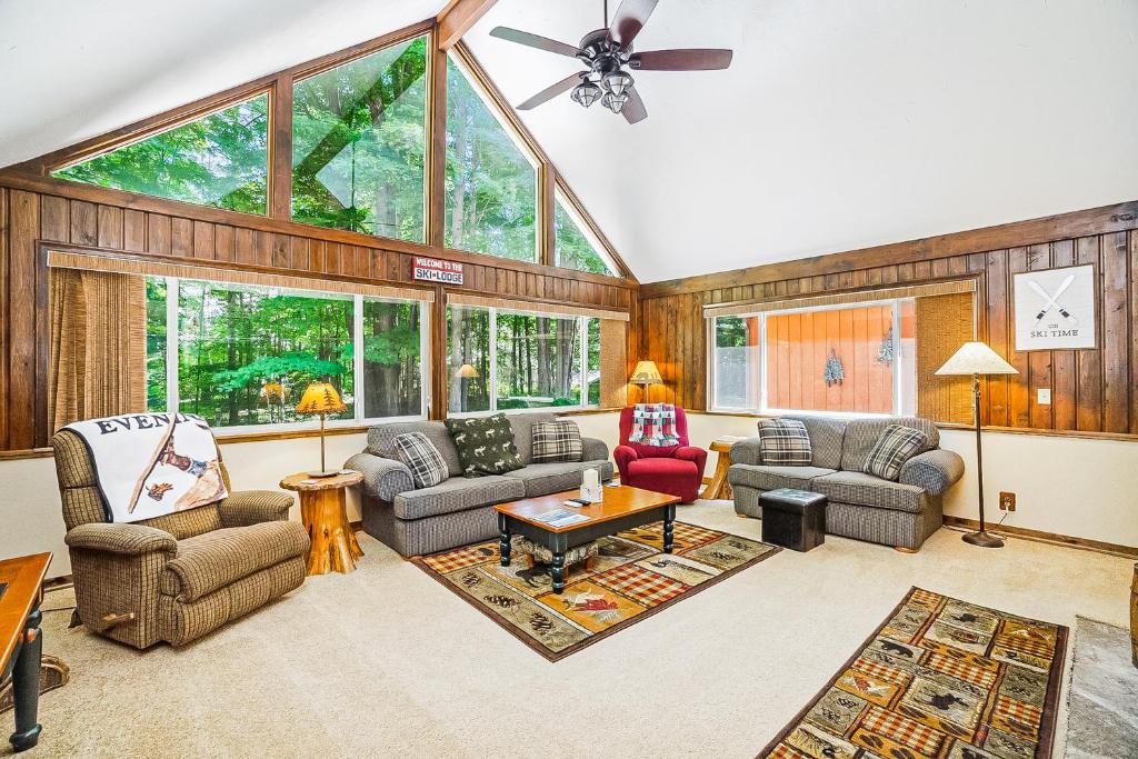 a living room with furniture and a large window at Ski Tips Up in Thompsonville