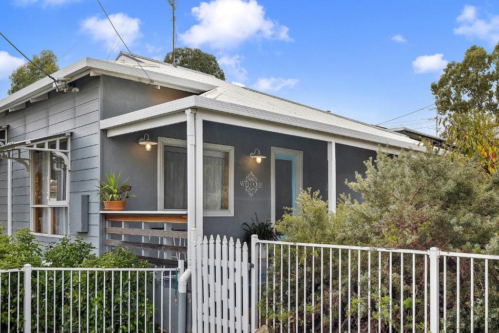 a grey house with a white fence in front of it at Jack's House 2 B&B in Mill Street in Clare