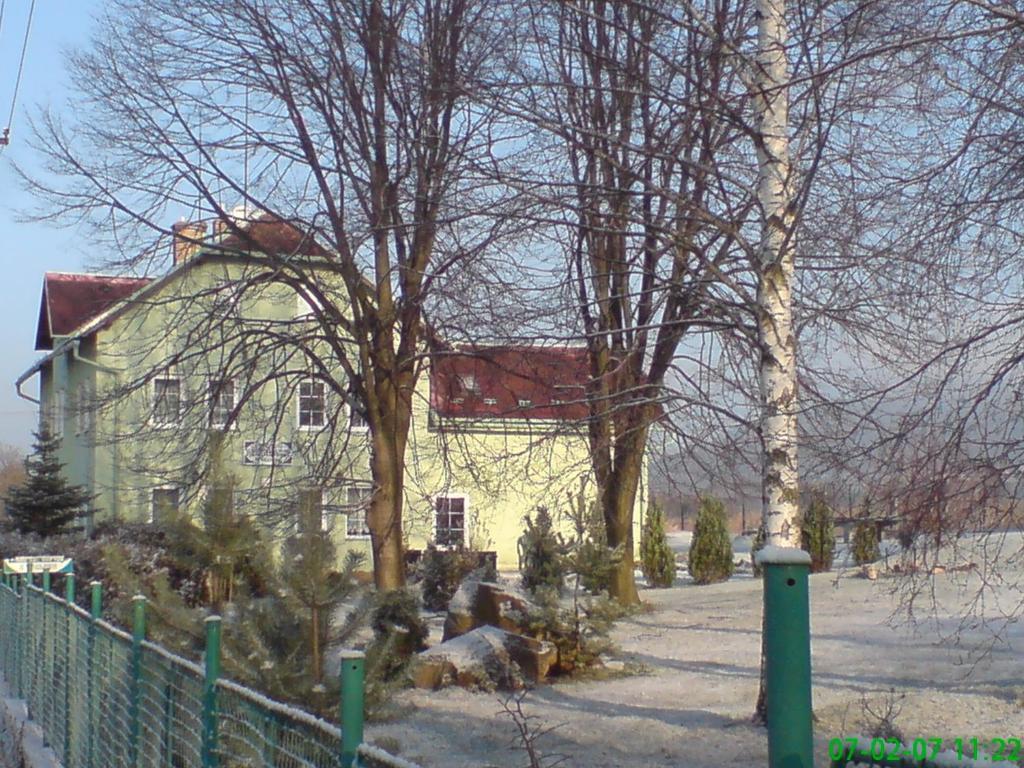 a house with trees in front of a fence at Pension U Václava in Janov