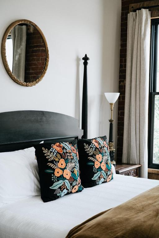 a bed with two pillows and a mirror on the wall at The Inn in Buena Vista