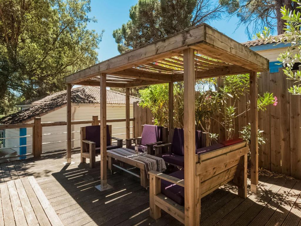 a wooden gazebo with chairs on a deck at Lavender holiday home with private terrace in Grimaud