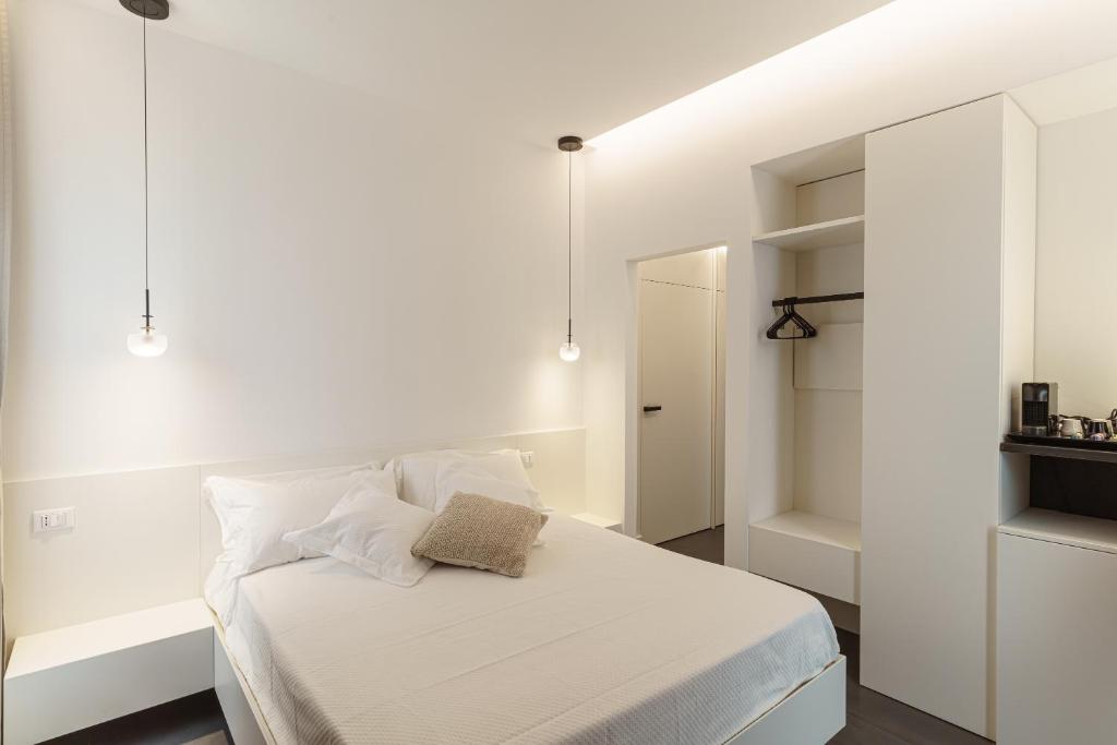 a bedroom with a bed with white sheets and pillows at B&B Nel Blu Dipinto Di Blu in Polignano a Mare