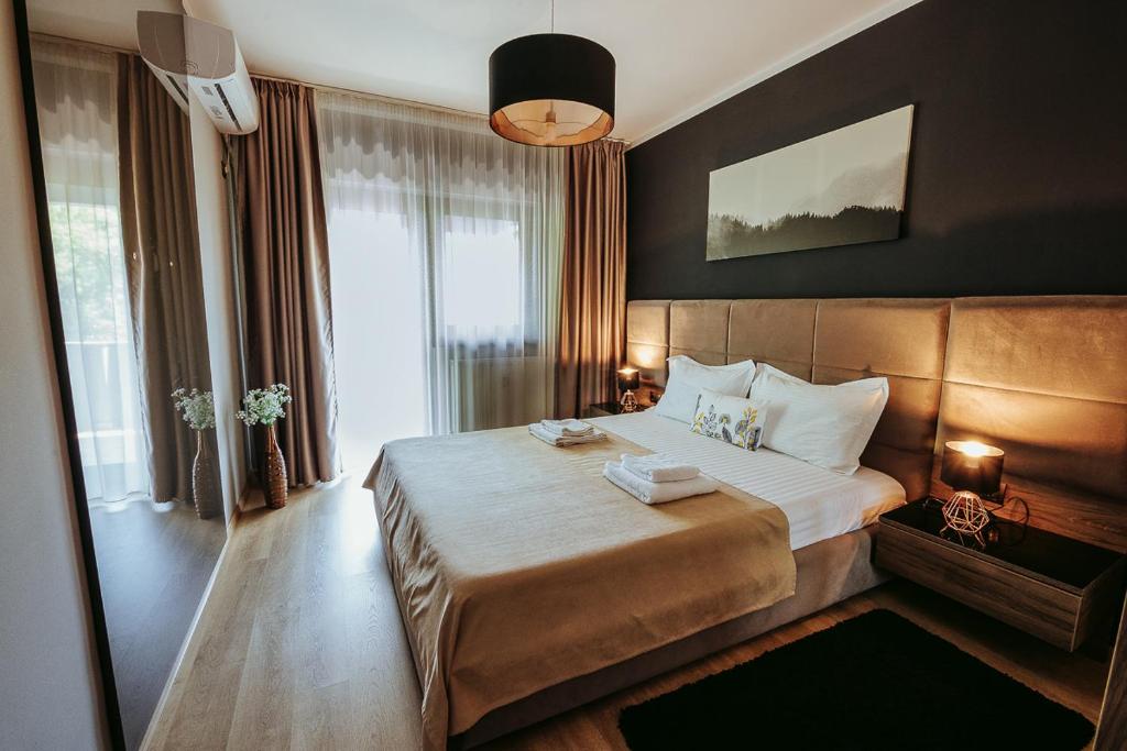 een hotelkamer met een groot bed en een groot raam bij Charlotte Apartment - 2Bedrooms w Parking near Nymphaea in Oradea