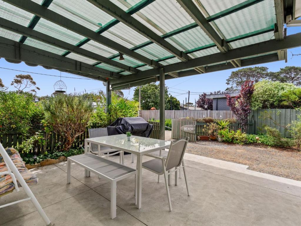 un patio avec une table et des chaises sous une pergola dans l'établissement Parkside Original 35, à Torquay
