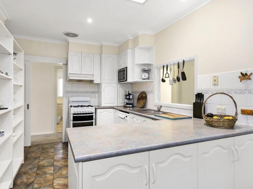 a kitchen with white cabinets and a counter top at Francis Geelong 156 in Belmont