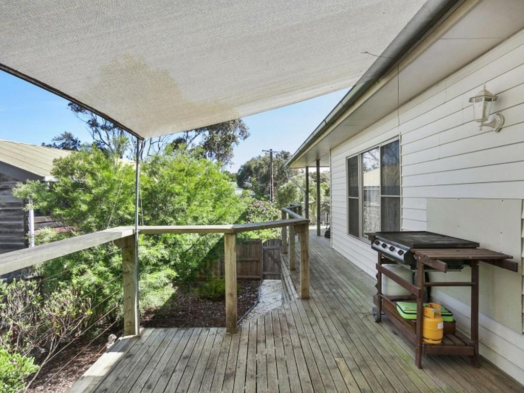 a screened porch with a grill on a house at Coffey Court Cottage 2 in Torquay