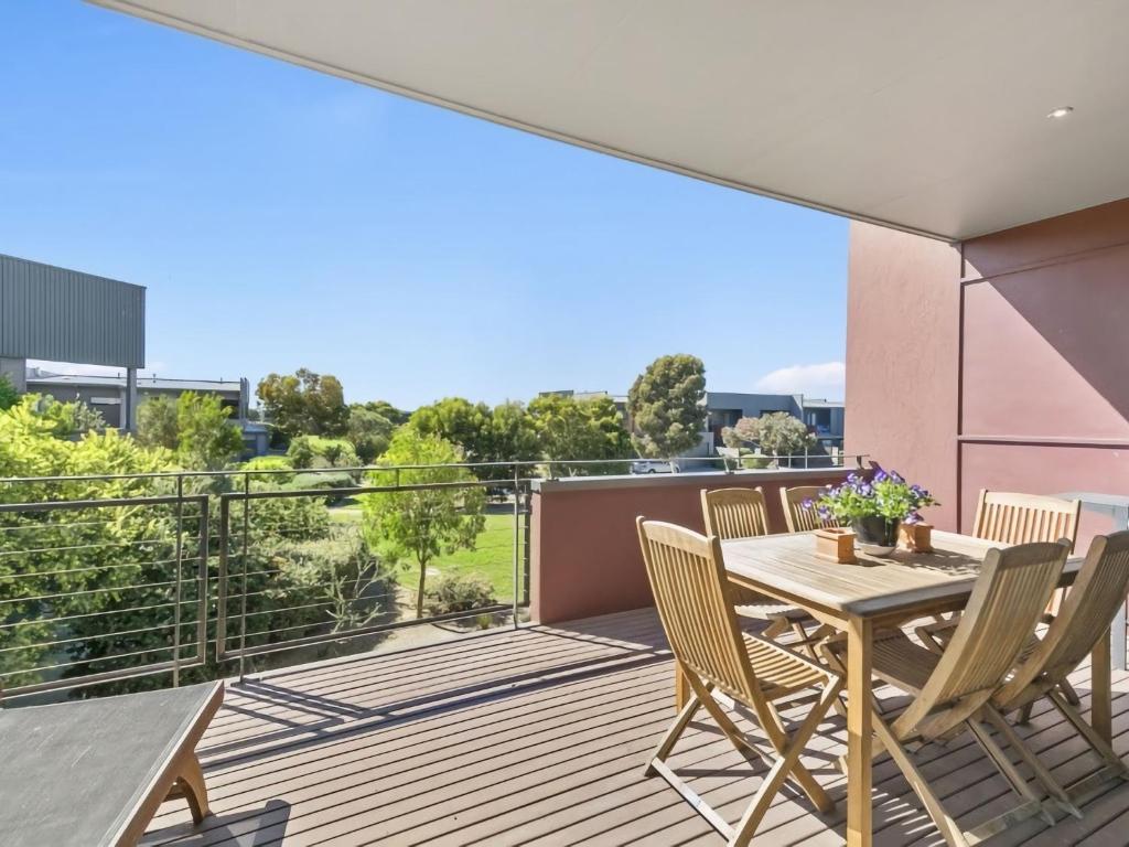 a patio with a table and chairs on a balcony at Coast Drive Beach and Golf 31 in Torquay