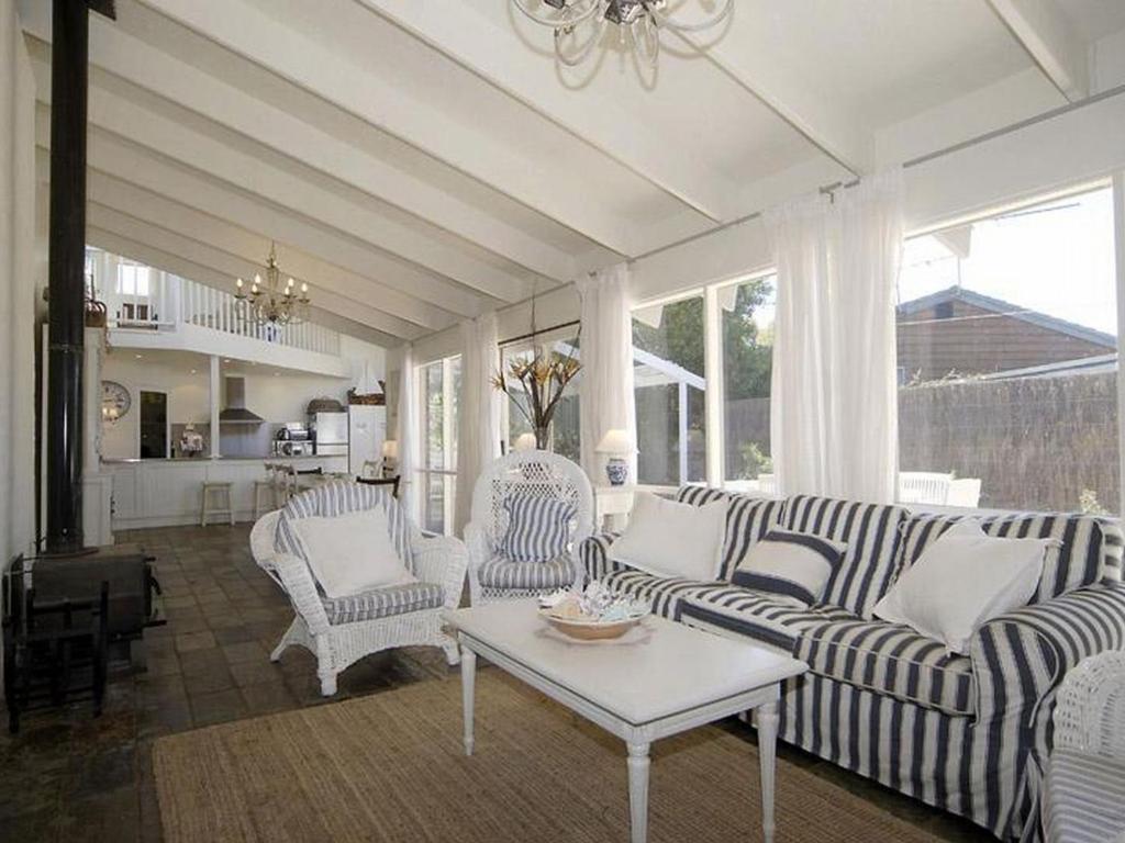 a living room with two couches and a table at Barnett Place 6 in Torquay