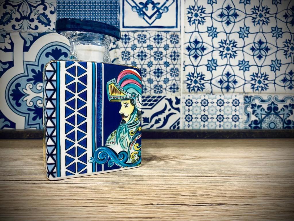 une bouteille avec une peinture d'une femme sur elle dans l'établissement Paolanna Rooms Affittacamere, à Syracuse