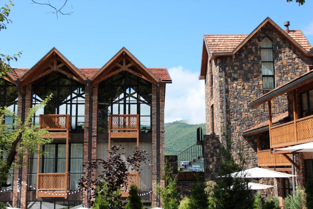 a large brick building with balconies on it at Dilijani Tun Hotel & Restaurant in Dilijan
