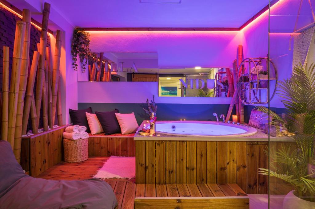 baño grande con bañera con iluminación púrpura en Nidus Villa en Souda