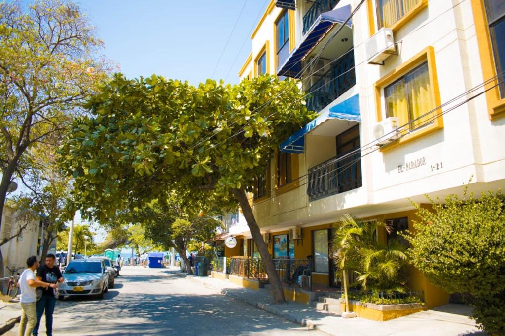 two people walking down a street next to a building at Acogedor apartamento a 15 metros del mar in Santa Marta