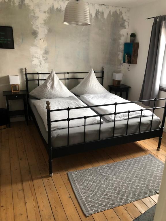 una cama con almohadas blancas en una habitación en [E] ifeel home_ Adenau, en Adenau