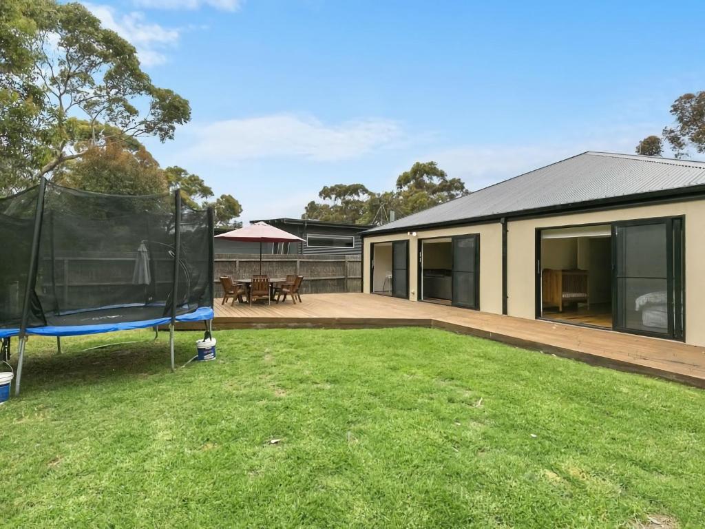 a house with a large yard with a trampoline at Paringa 15 Anglesea Beach House in Anglesea