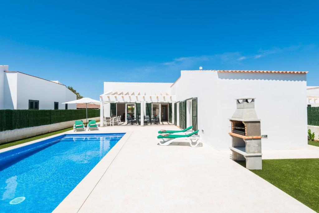 a villa with a swimming pool and a house at Villa Calan Bosch Es Bruc in Cala'n Bosch