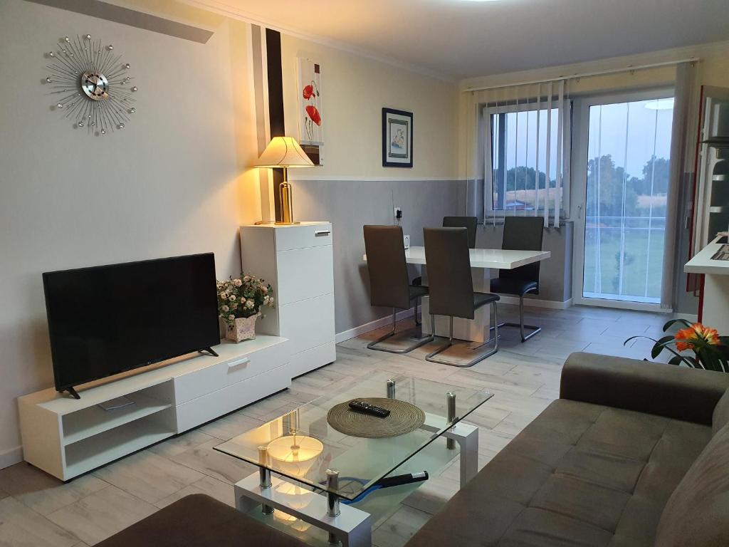 a living room with a television and a table with chairs at Lucys Haus 2 "am Peeneblick" in Peenemünde