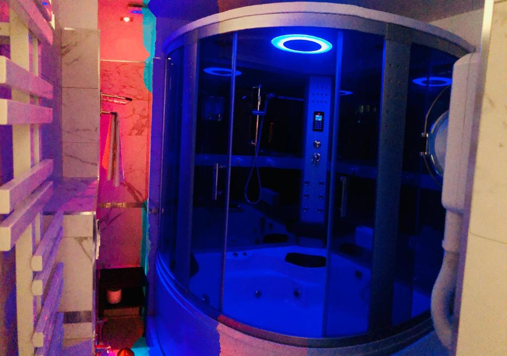 a bathroom with a shower with blue lights in it at parisa suite in Rome