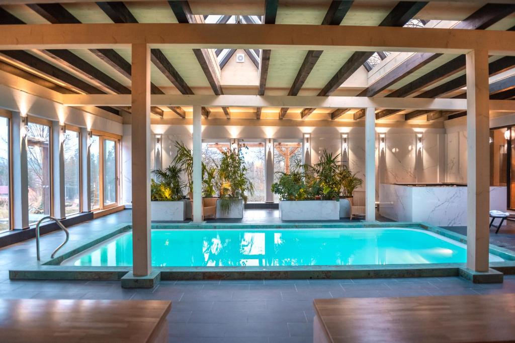 a swimming pool in a house with a ceiling at Welness penzion Modrý jelen in Lipno nad Vltavou