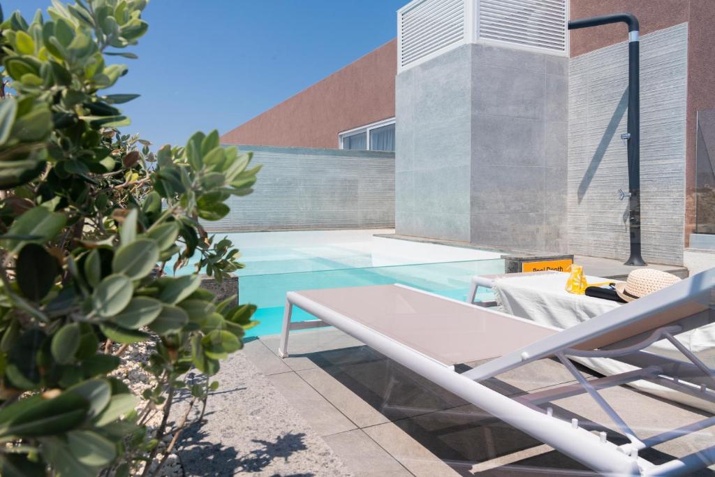 a swimming pool with a table and a chair at StayMela Apartments - Birkirkara in Birkirkara